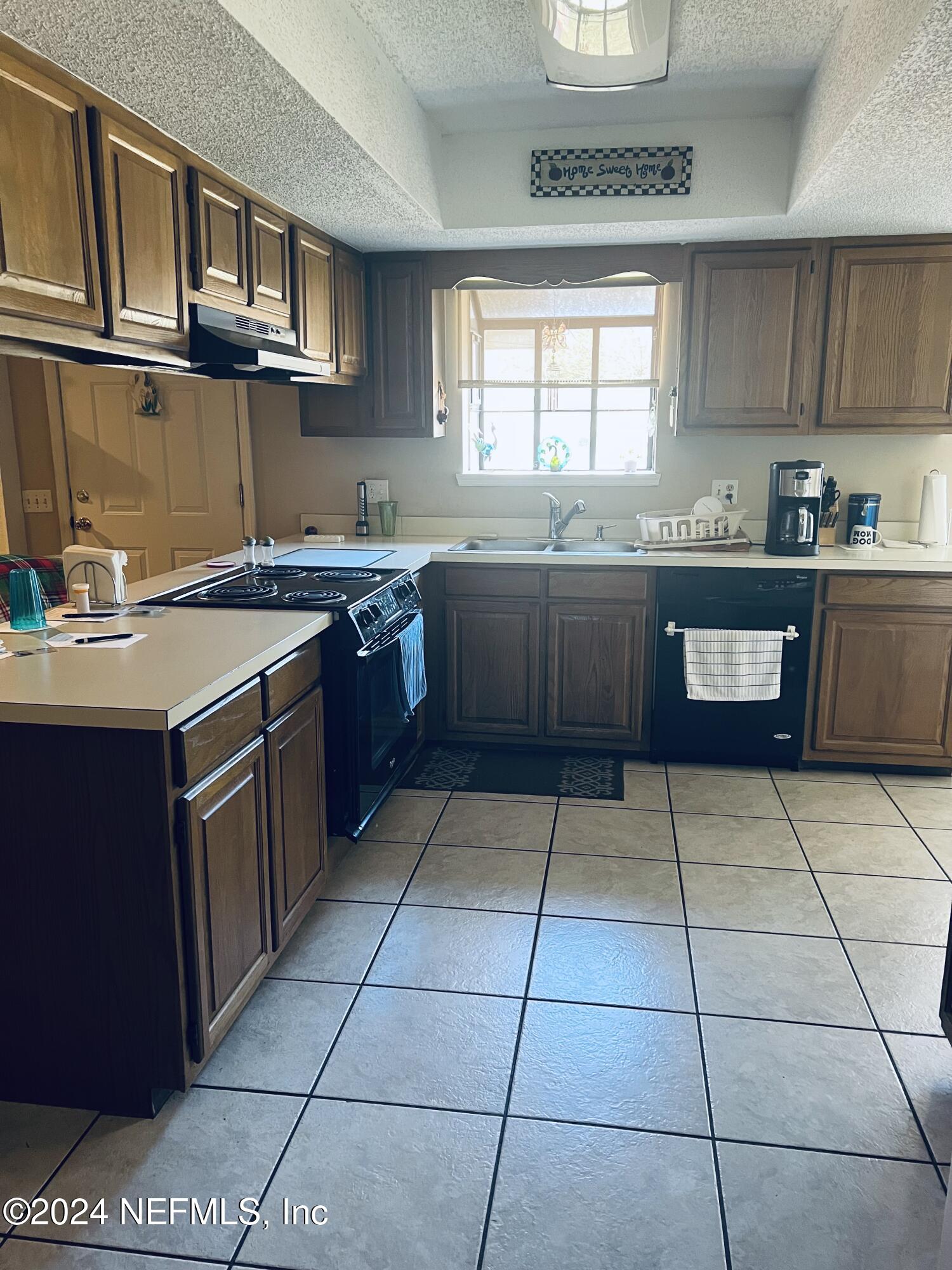 11375 Pine Loop Glen St. Mary, FL 32040 - Photo 7 of 17 a kitchen with stainless steel appliances granite countertop a stove a sink and a microwave