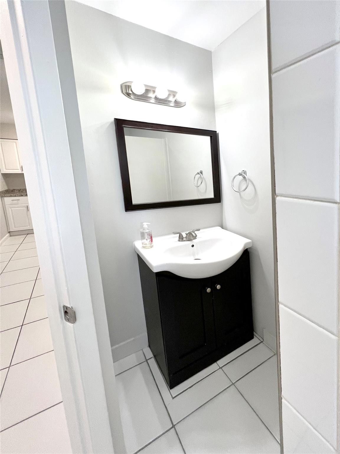 121 Southwest 15th Street, Unit C Pompano Beach, FL 33060 - Photo 11 of 13 a bathroom with a sink and a mirror