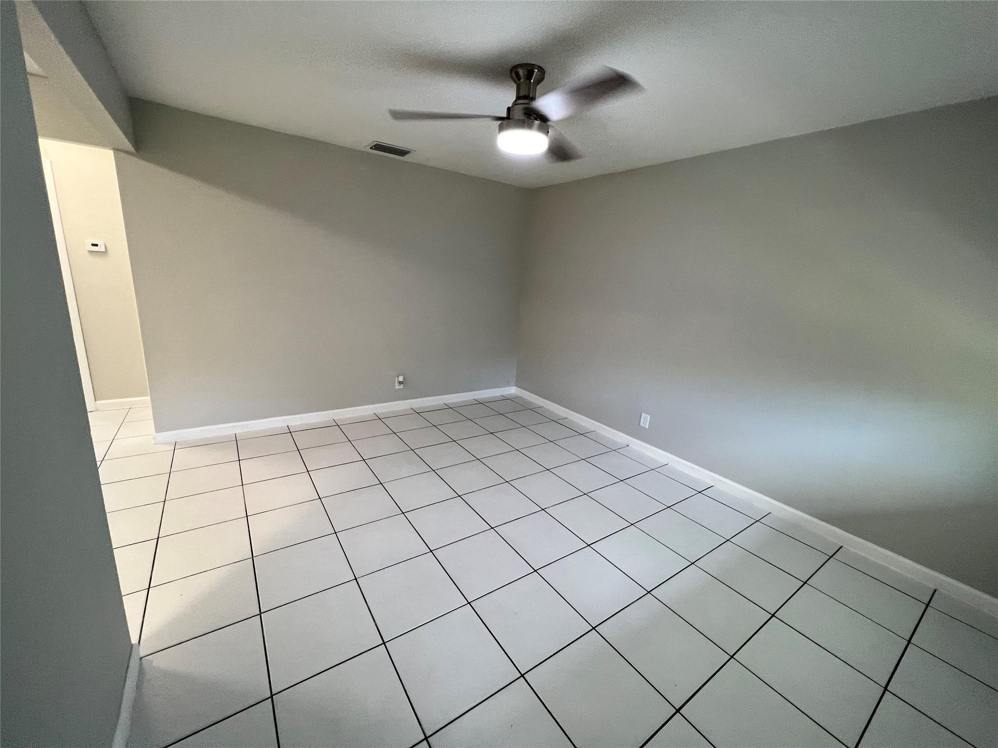 121 Southwest 15th Street, Unit C Pompano Beach, FL 33060 - Photo 4 of 13 an empty room with windows