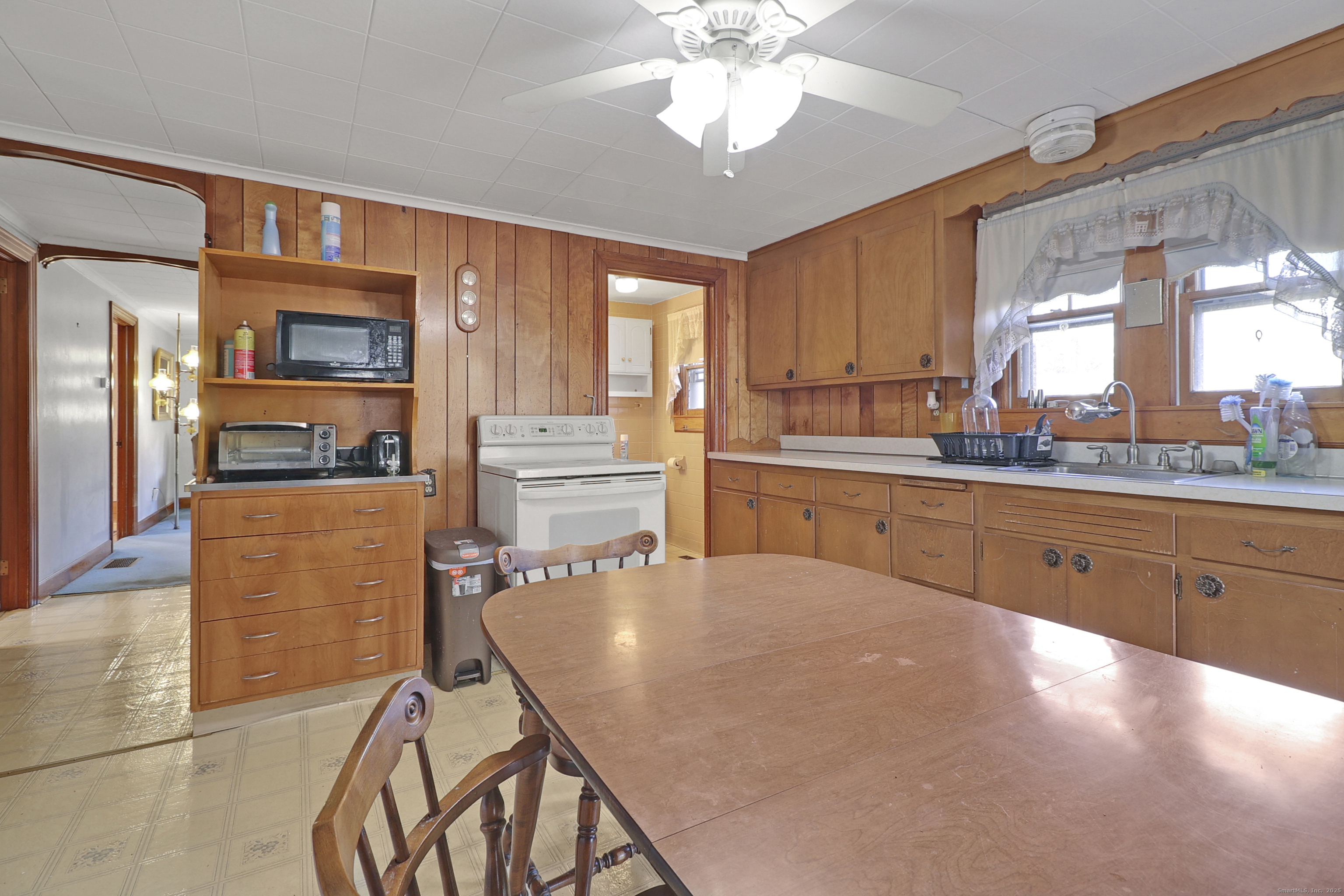 60 Frost Street Southington, CT 06479 - Photo 31 of 35 a kitchen with stainless steel appliances granite countertop a stove top oven a sink a dining table and chairs with wooden floor