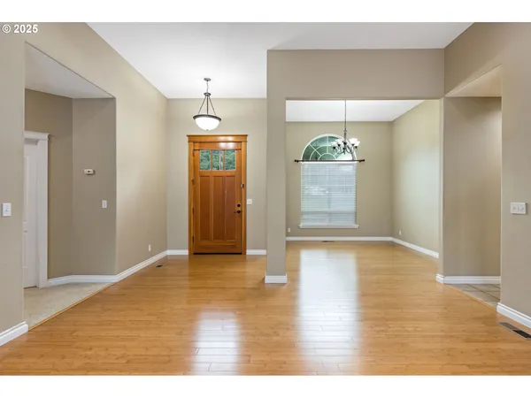a view of an empty room with kitchen and window