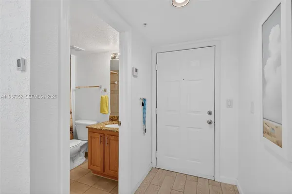 a bathroom with a granite countertop toilet a sink and shower