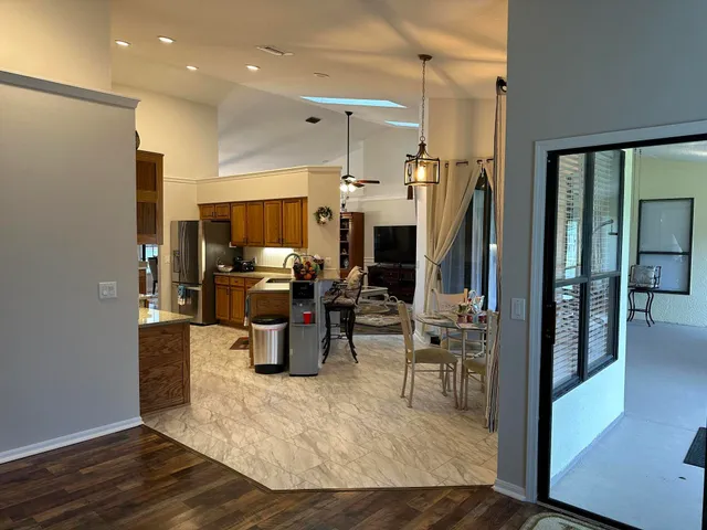 a kitchen with stainless steel appliances kitchen island granite countertop a refrigerator and a sink