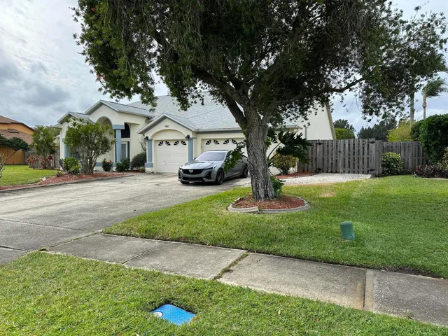 a front view of a house with a yard and trees