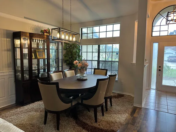 a view of a dining room with furniture a chandelier and wooden floor