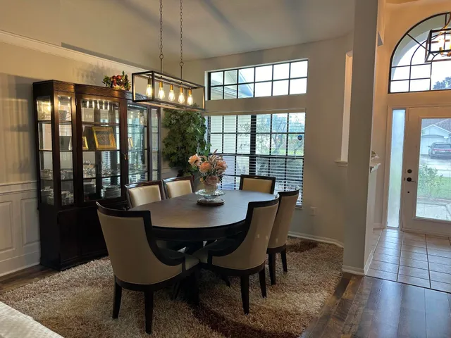 a view of a dining room with furniture a chandelier and wooden floor