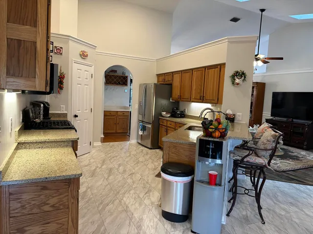 a kitchen with stainless steel appliances kitchen island granite countertop a stove and a refrigerator