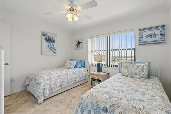 a bedroom with two beds and a large window