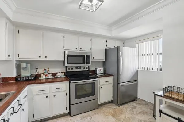 a kitchen with cabinets stainless steel appliances and window