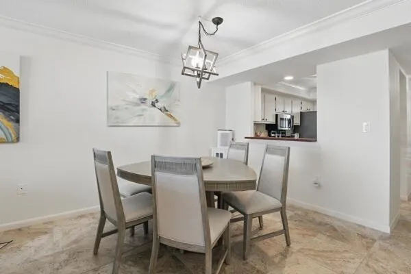 a view of a dining room with furniture a chandelier and wooden floor