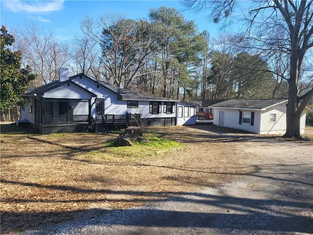 a view of a house with a yard and large tree