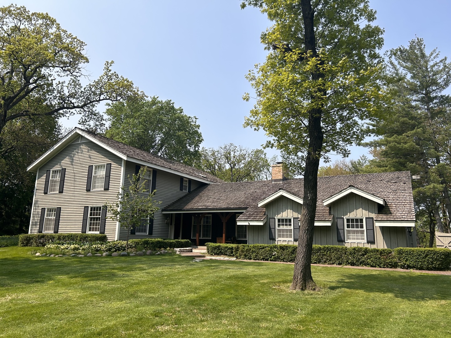 a front view of a house with a garden and trees