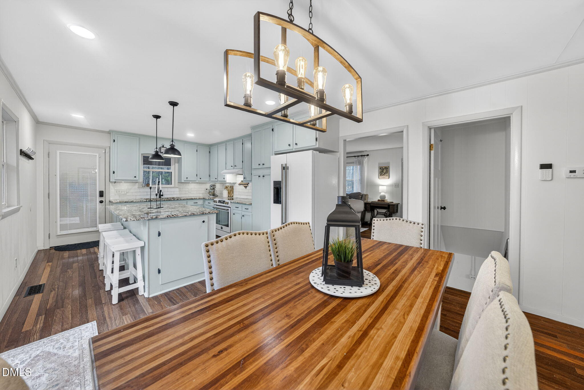 2808 Carpenter Pond Road Raleigh, NC 27613 - Photo 12 of 49 a open dining room with wooden floor a chandelier a wooden table and chairs