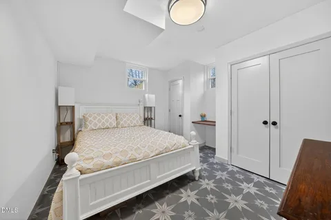 a bedroom with a bed and a refrigerator