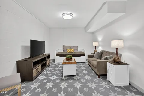 a living room with furniture a flat screen tv and a table