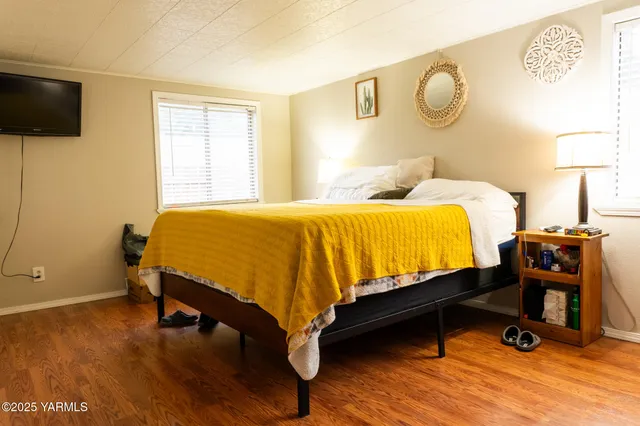a bedroom with a bed and wooden floor