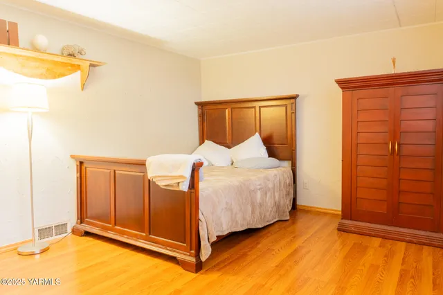 a bedroom with a bed and wooden floor