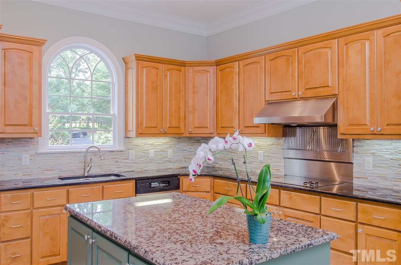 12016 Shooting Club Road Raleigh, NC 27613 - Photo 11 of 25 a kitchen with stainless steel appliances granite countertop a sink a counter space and cabinets