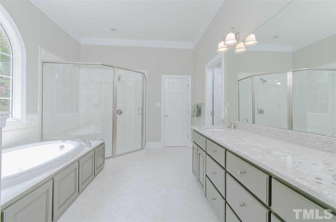 12016 Shooting Club Road Raleigh, NC 27613 - Photo 16 of 25 a spacious bathroom with a granite countertop sink a toilet a mirror and shower