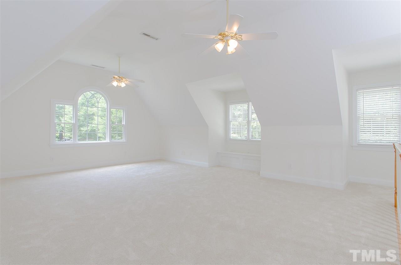 12016 Shooting Club Road Raleigh, NC 27613 - Photo 18 of 25 an empty room with windows and chandelier fan
