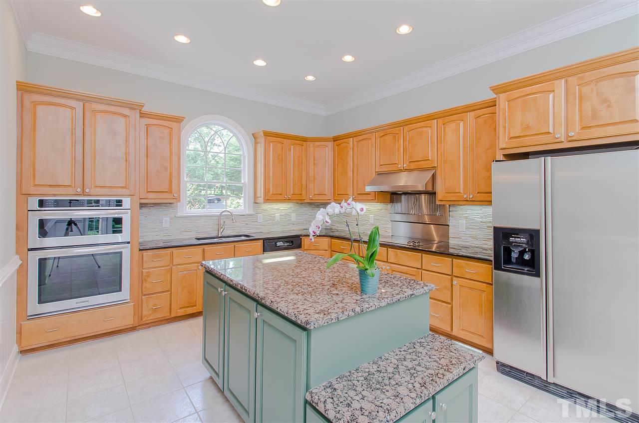 12016 Shooting Club Road Raleigh, NC 27613 - Photo 9 of 25 a kitchen with stainless steel appliances granite countertop a stove a sink and a refrigerator