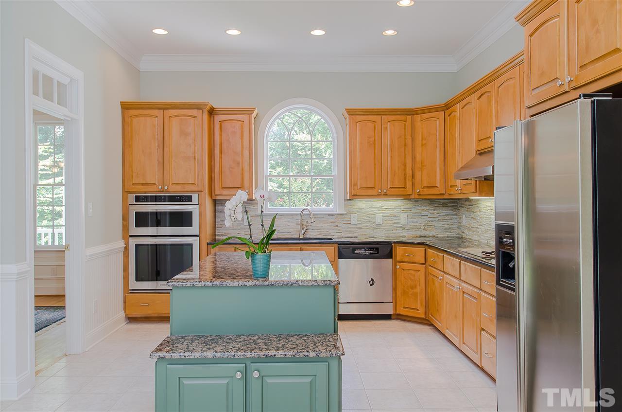 12016 Shooting Club Road Raleigh, NC 27613 - Photo 10 of 25 a kitchen with stainless steel appliances granite countertop a stove a sink and a refrigerator