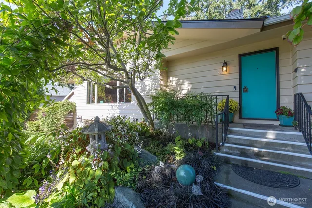 a front view of a house with plants and trees
