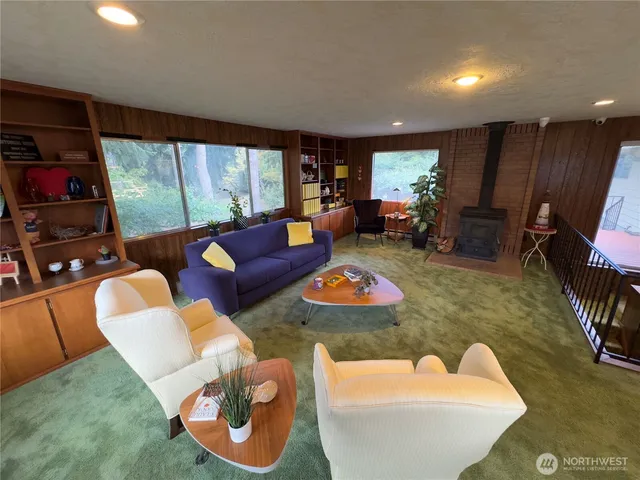 a living room with furniture a flat screen tv and a large window