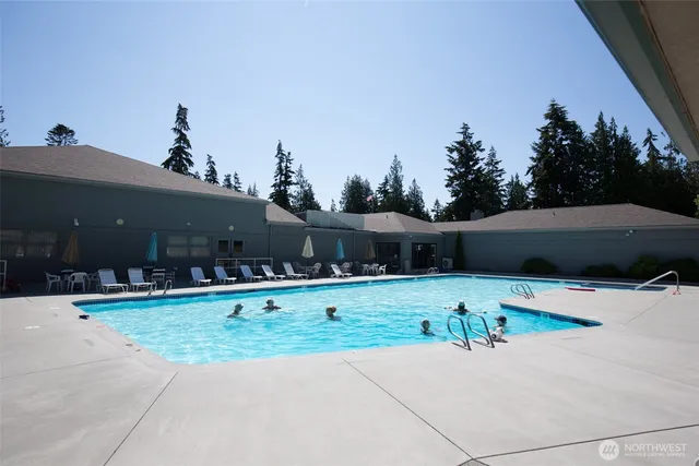 a swimming pool with barbeque oven and outdoor seating
