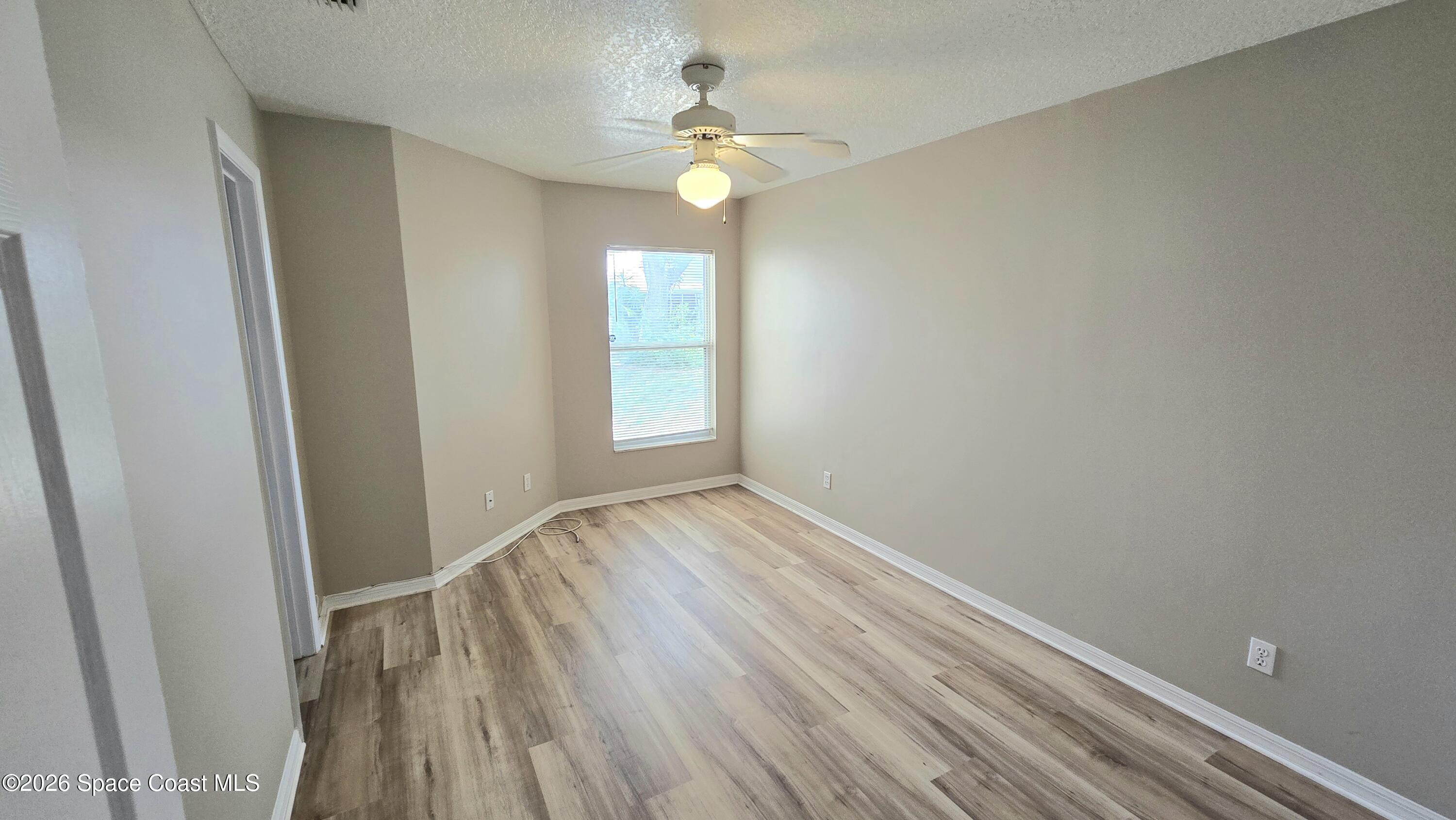 1977 Myrtle Court Palm Bay, FL 32905 - Photo 15 of 19 a view of empty room with wooden floor and fan