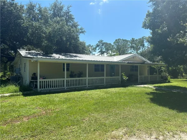 a view of a house with a yard and sitting area