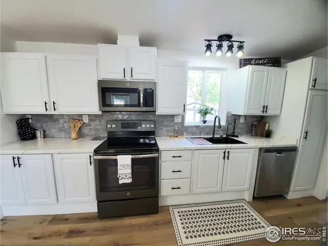 a kitchen with stainless steel appliances a stove a sink and a microwave