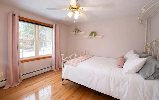 a bedroom with a bed chandelier and a window