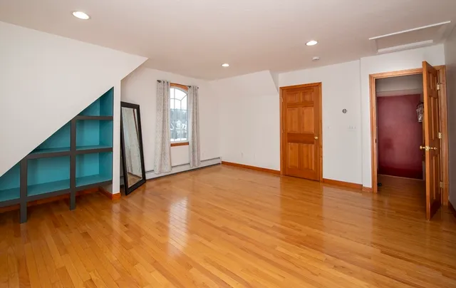 a view of empty room with wooden floor