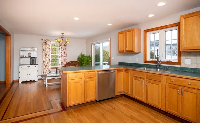 a large kitchen with granite countertop a large window and stainless steel appliances