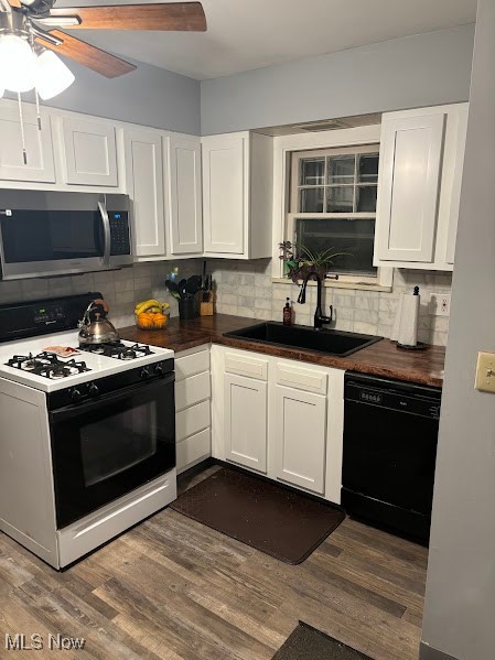 1019 Quilliams Road Cleveland Heights, OH 44121 - Photo 10 of 32 Kitchen with gas range, white cabinetry, stainless steel microwave, black dishwasher, and decorative backsplash