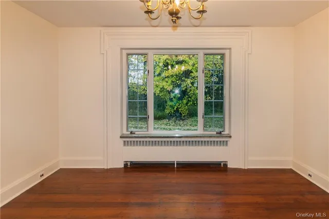 a view of a livingroom with wooden floor and a window