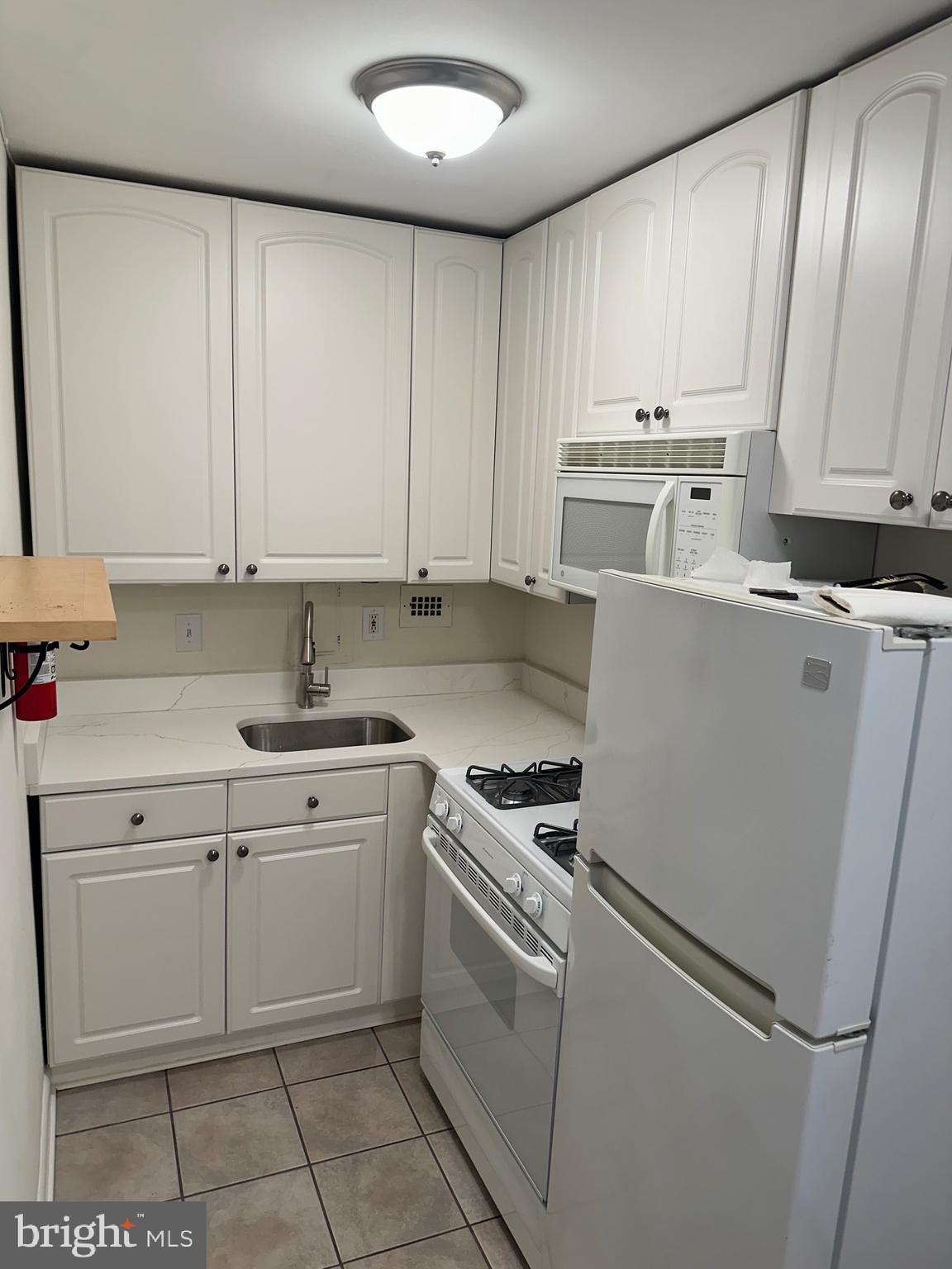 922 24th Street Northwest, Unit 608 Washington, DC 20037 - Photo 12 of 13 a kitchen with a stove top oven sink and cabinets