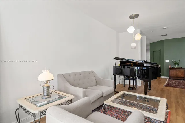 a living room with furniture a dining table and a chandelier