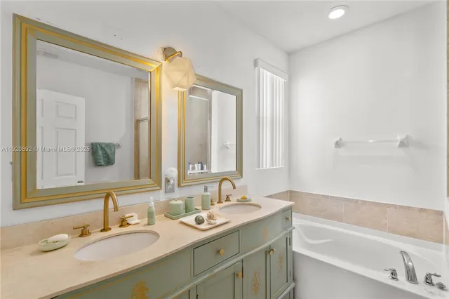 a bathroom with a tub sink and mirror