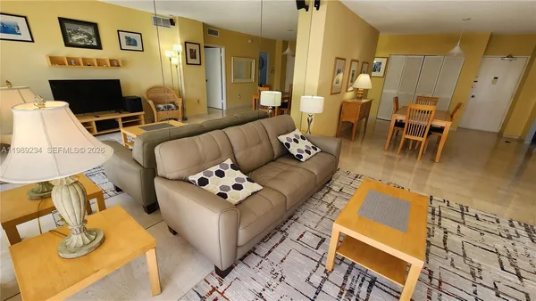 a living room with furniture flat screen tv and a table