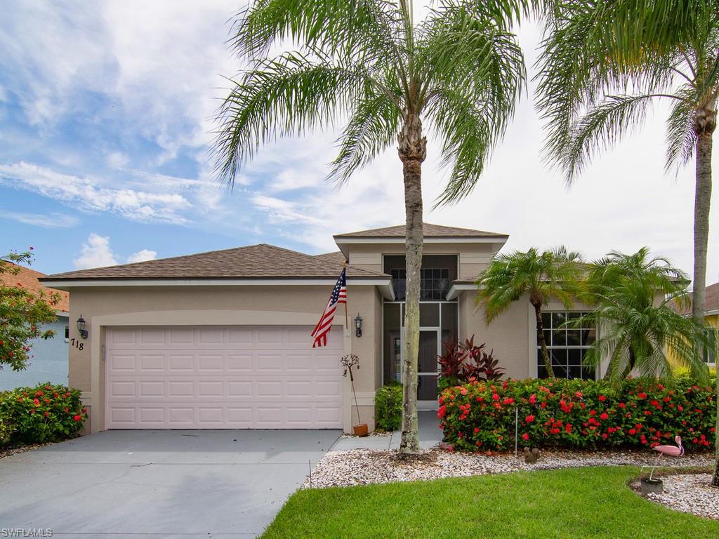 front view of house with a yard and palm trees