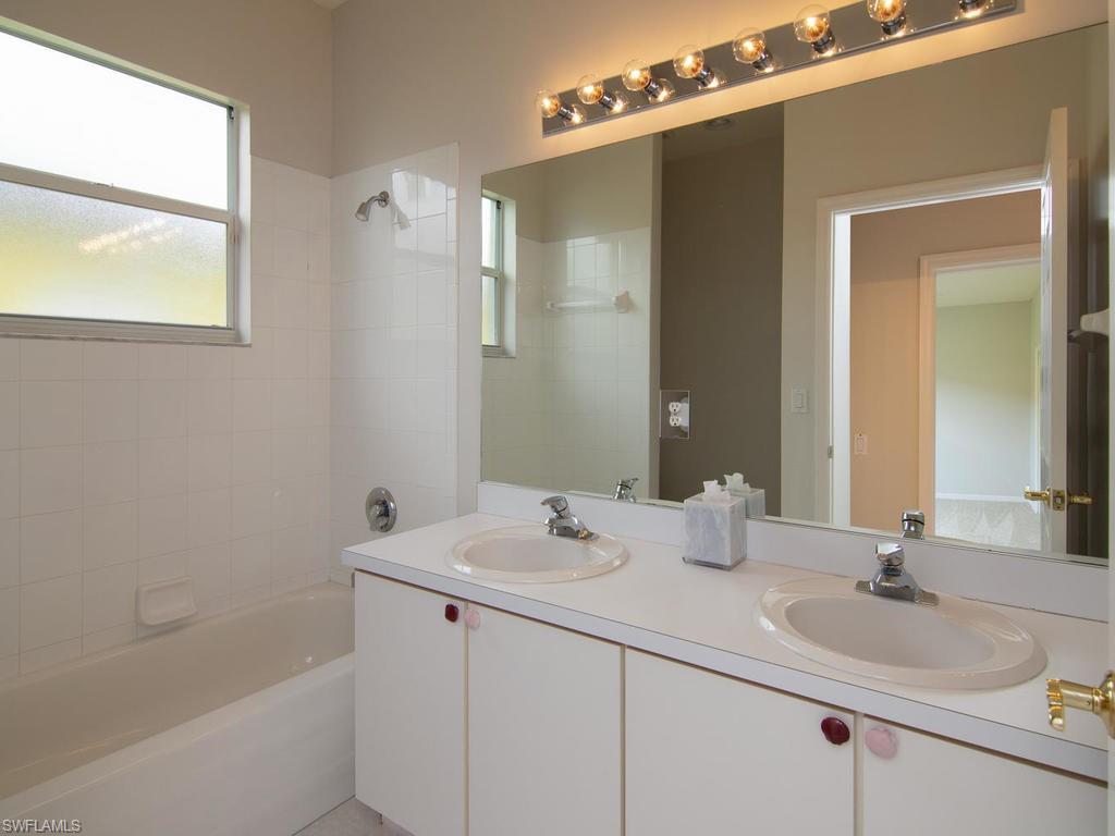 718 Crossfield Circle Naples, FL 34104 - Photo 12 of 17 a bathroom with a sink vanity tub and shower