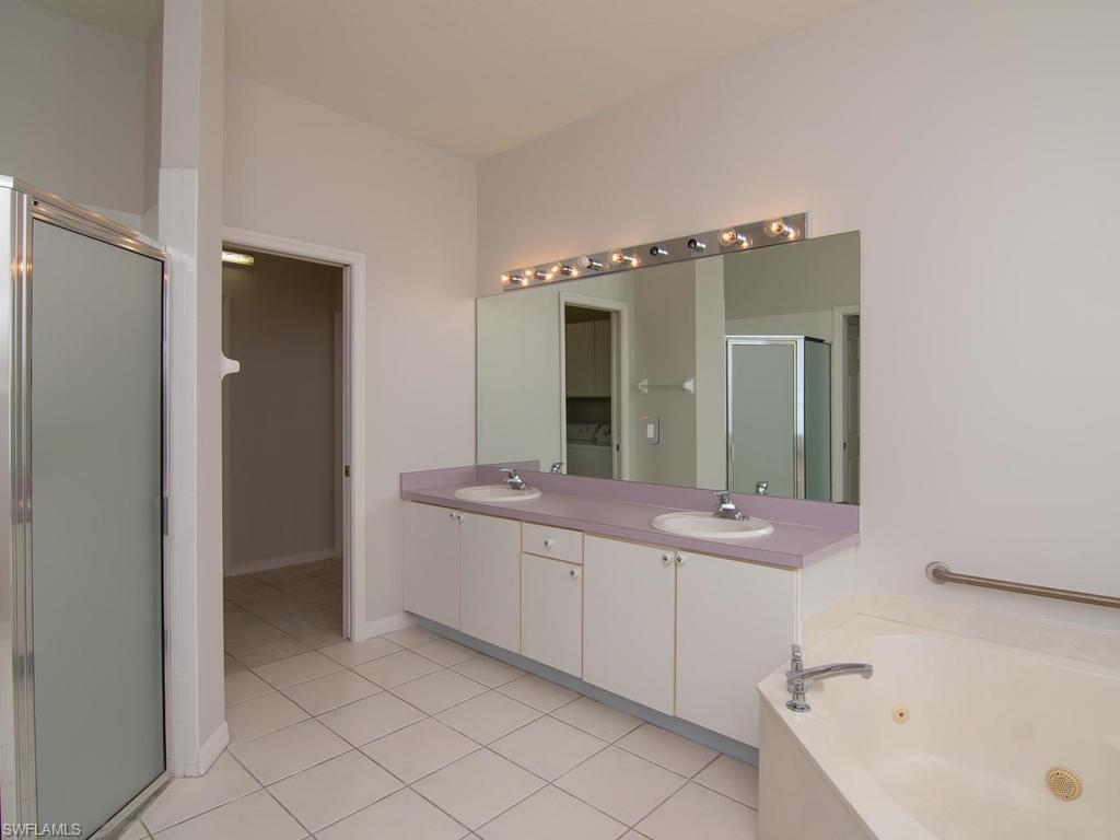 718 Crossfield Circle Naples, FL 34104 - Photo 10 of 17 a spacious bathroom with a bathtub sink and mirror
