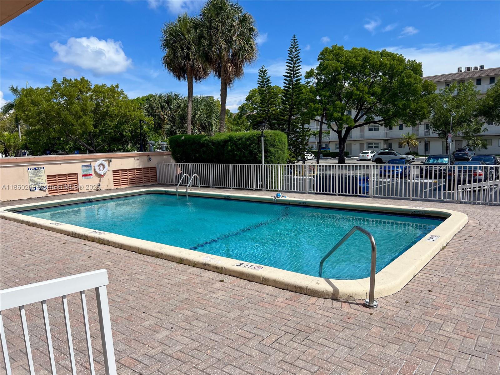 2200 East Hallandale Beach Boulevard, Unit 603 Hallandale Beach, FL 33009 - Photo 15 of 17 a view of a swimming pool with a lounge chairs