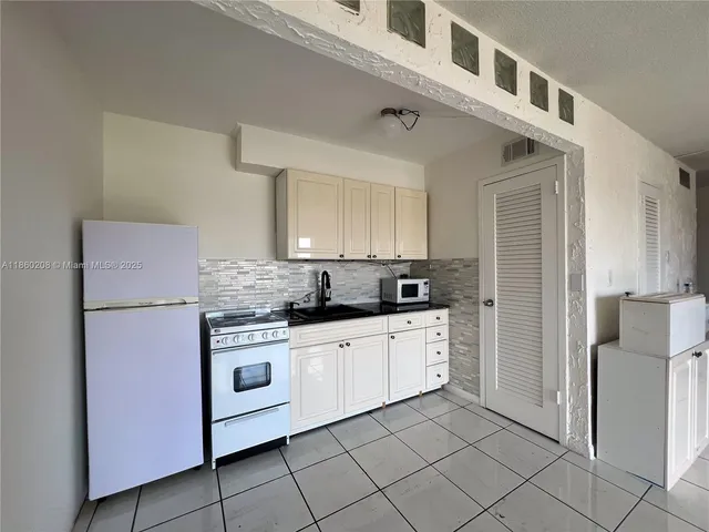 a kitchen with white cabinets and white appliances