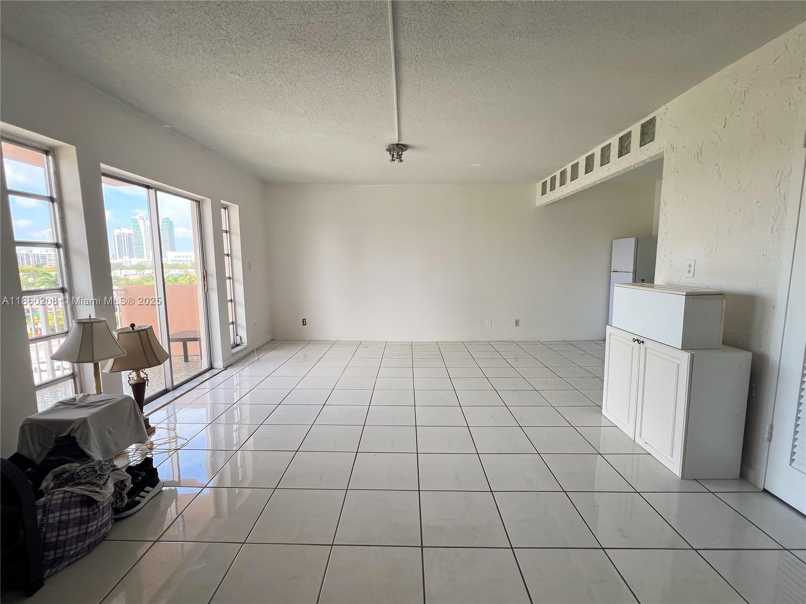 2200 East Hallandale Beach Boulevard, Unit 603 Hallandale Beach, FL 33009 - Photo 9 of 17 a view of a livingroom with kitchen and furniture