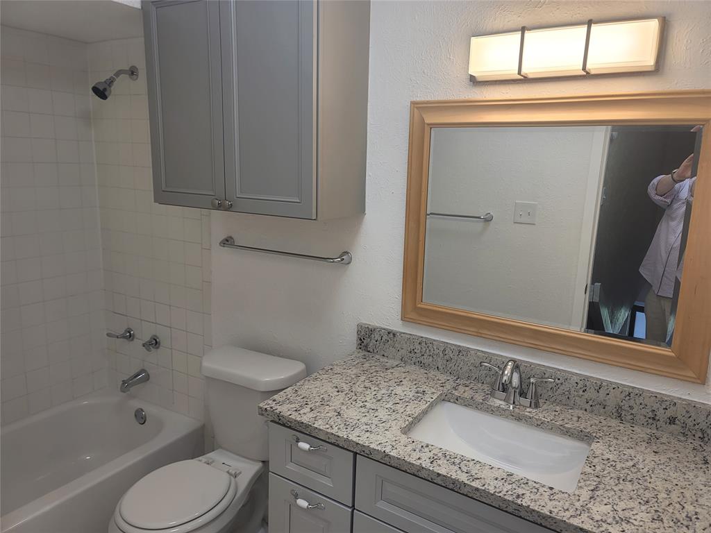 4616 Country Creek Drive, Unit 1176 Dallas, TX 75236 - Photo 11 of 19 a bathroom with a granite countertop sink toilet and shower