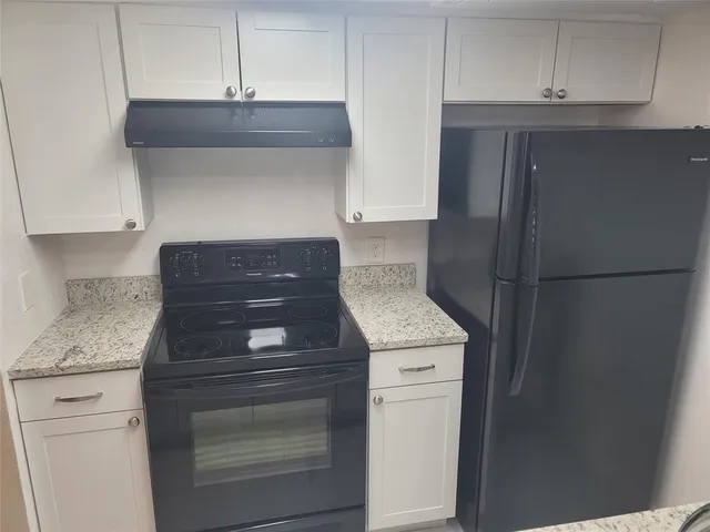 a kitchen with granite countertop cabinets and oven