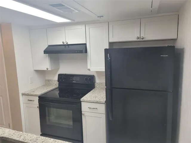 a kitchen with stainless steel appliances granite countertop white refrigerator and stove